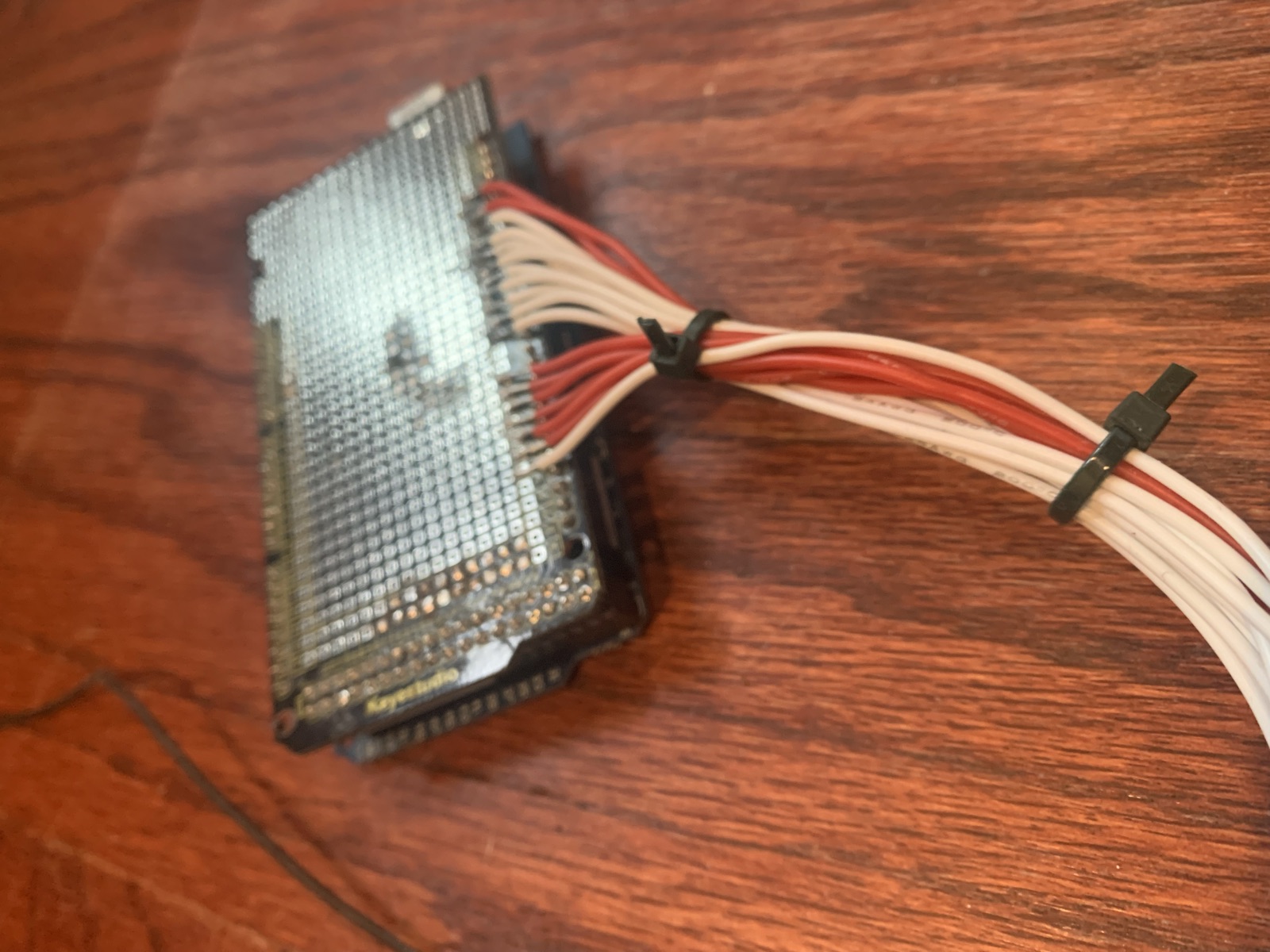 The same wiring shield seen mounted with the harness looped and tied above it