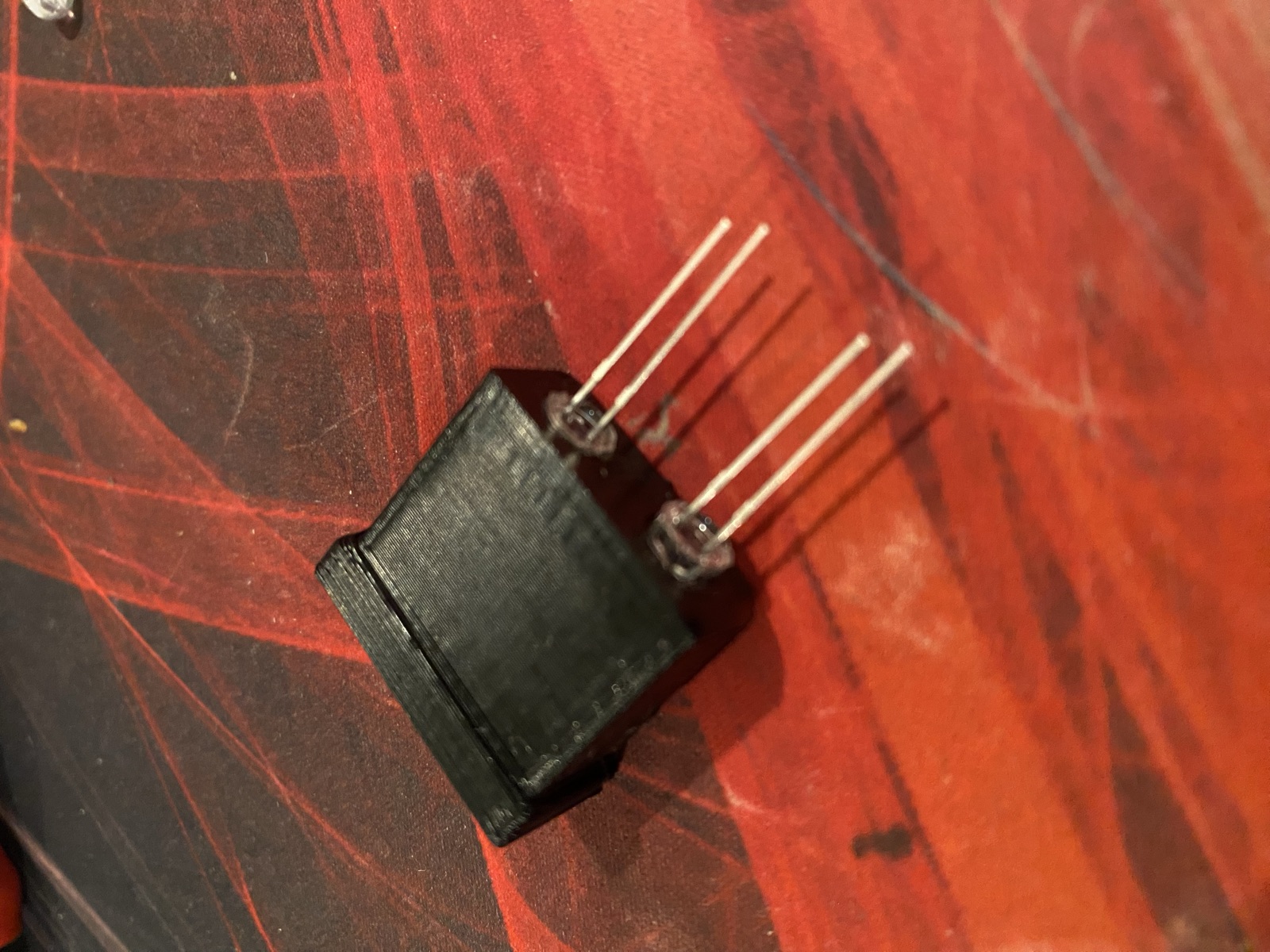 A small black light box holding two LEDs with their legs bent out for wiring
