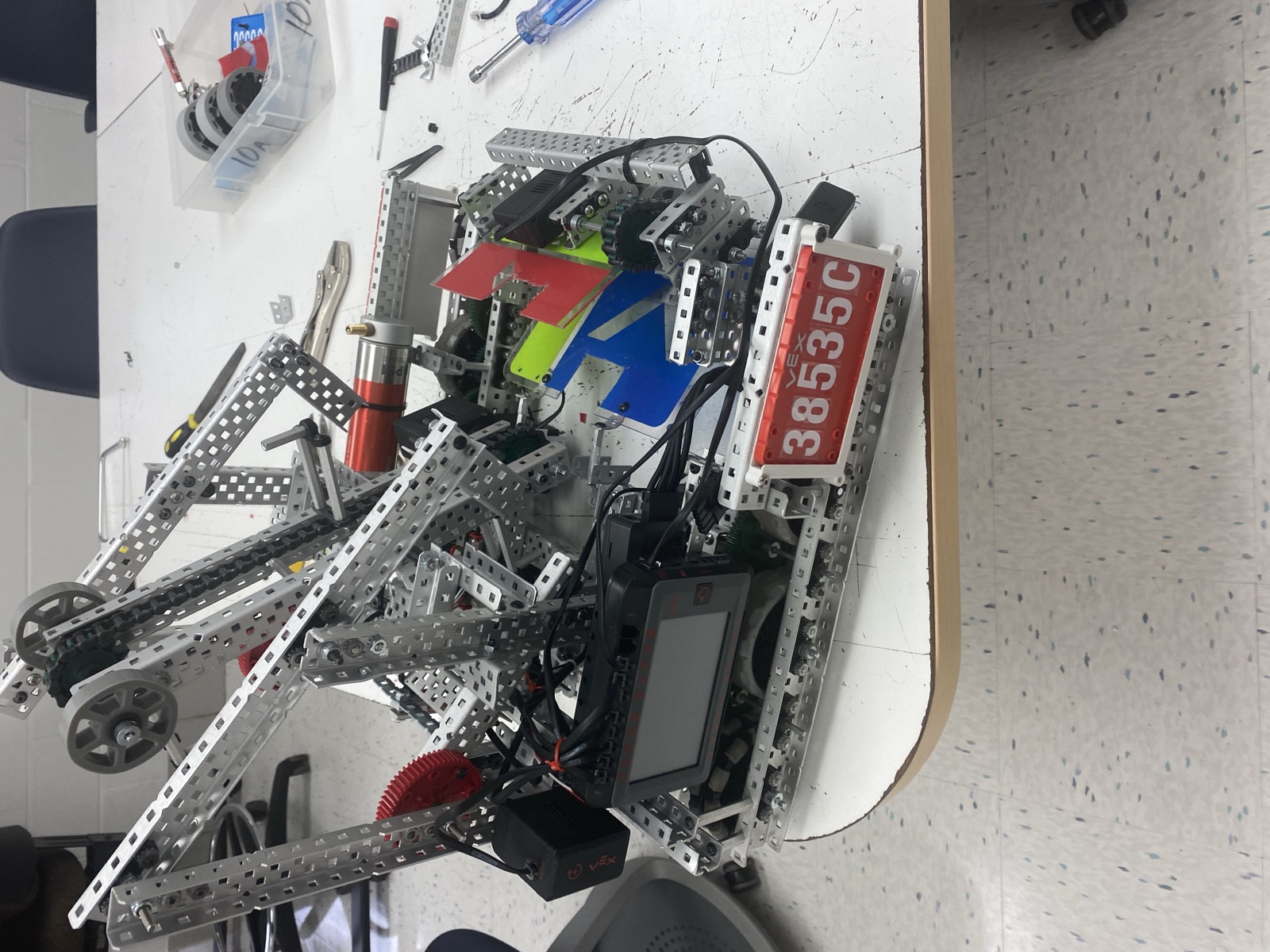 High Stakes Robot 1 on the workbench showing the tread base, tall arm, and V5 brain