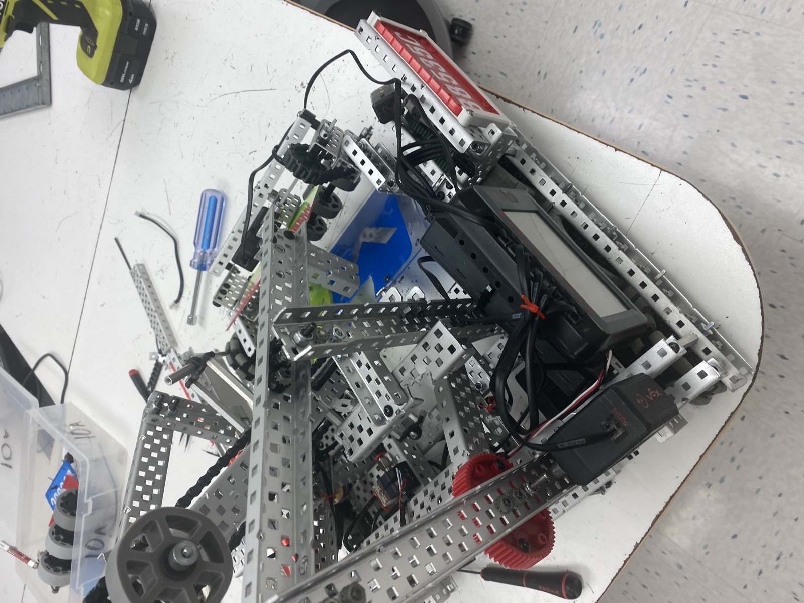 Close view of the robot frame with the arm, gears, and wiring during a build session