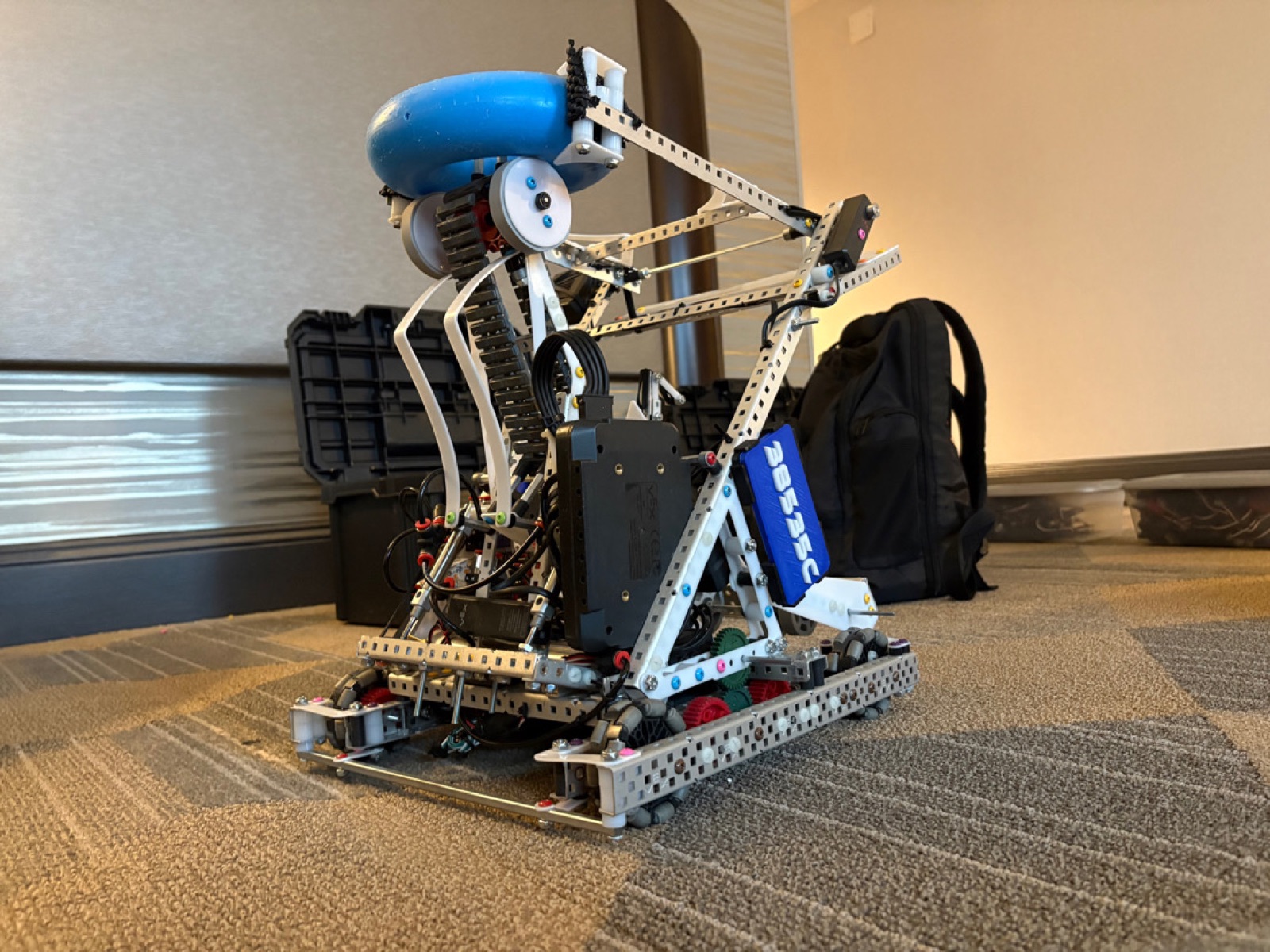 Built robot at home with the arm raised, a ring on the arm, and the controller in hand