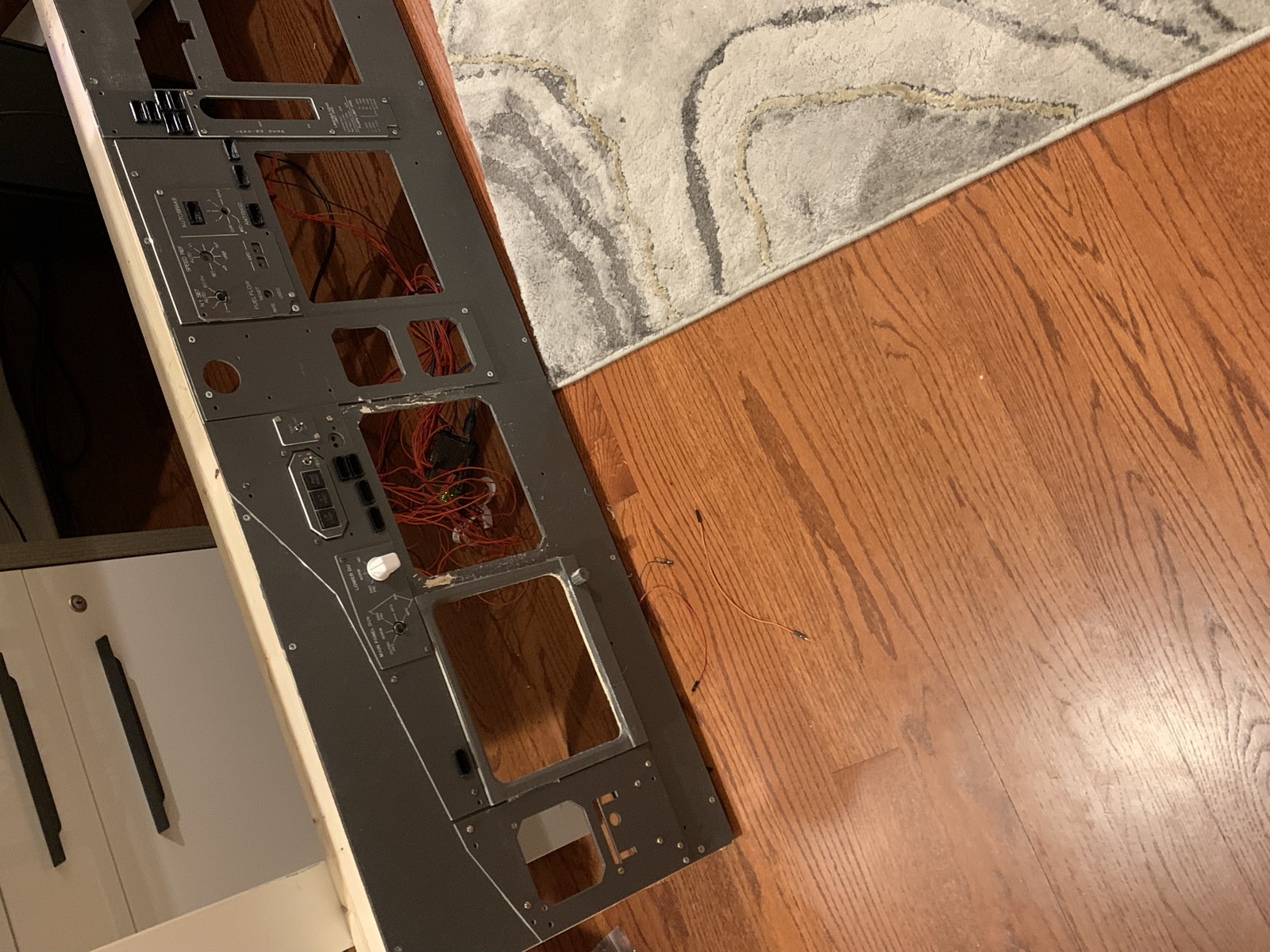 Lower half of the panel with an Arduino and red wire harness attached