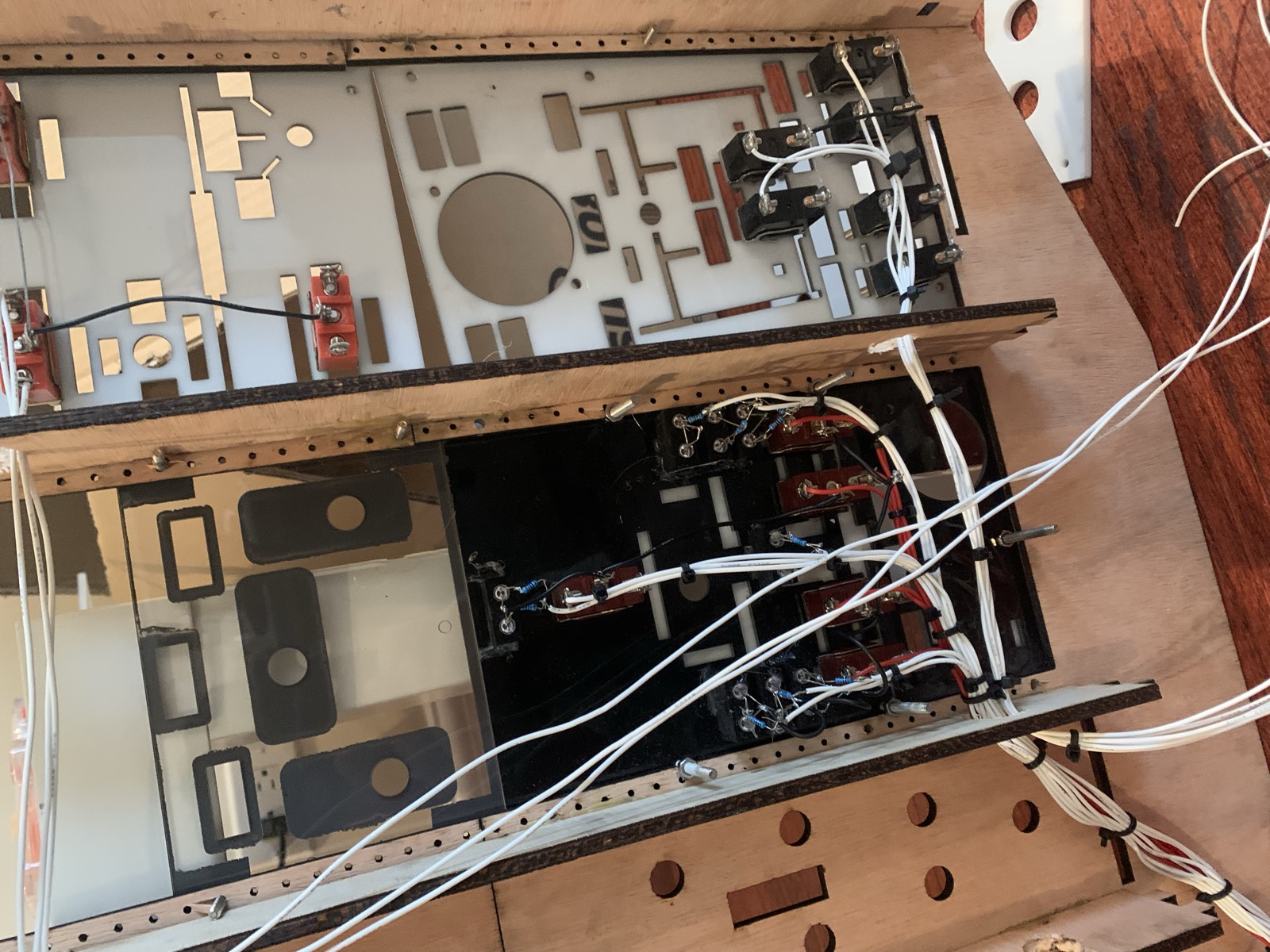 Back side of the overhead panels showing hand soldered switches, resistors and bundled white wiring